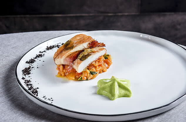 Schmackhafter Fisch im Speckmantel auf einem Gemüserisotto im Genussdorf Gmachl in Bergheim bei Salzburg